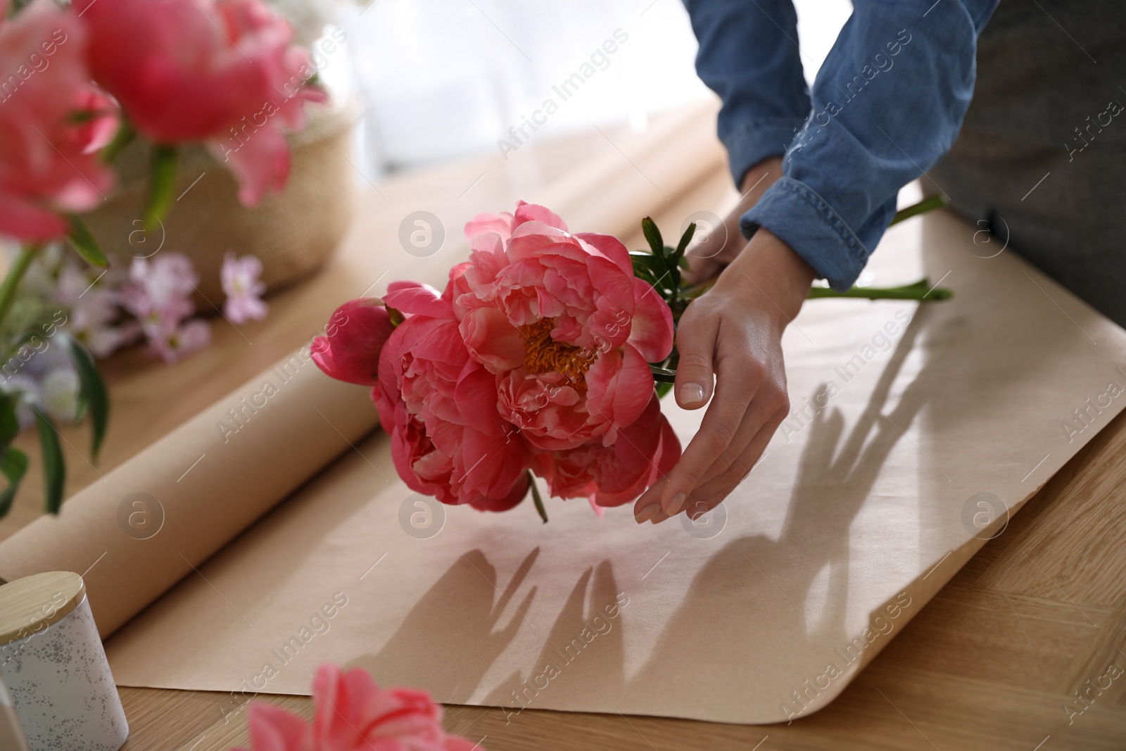 Photo of Florist making beautiful peony bouquet at table, closeup