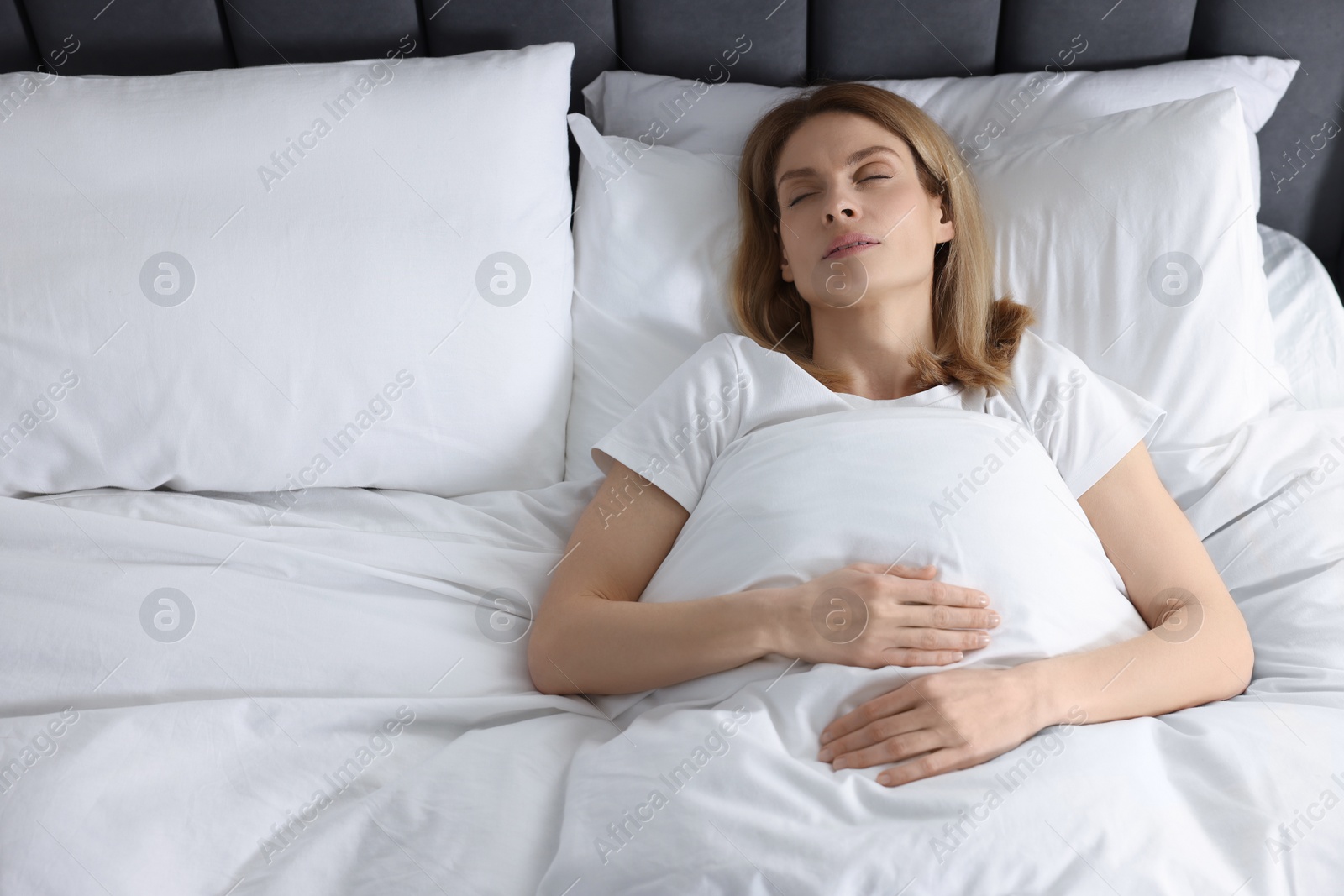 Photo of Woman snoring while sleeping in bed at home