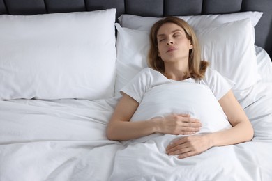 Woman snoring while sleeping in bed at home