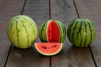 Photo of Different delicious ripe watermelons on wooden table