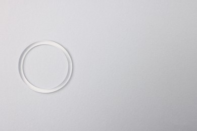 Diaphragm vaginal contraceptive ring on grey background, top view. Space for text