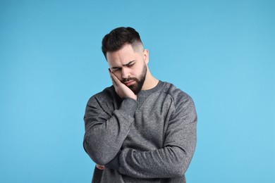 Photo of Portrait of sad man on light blue background