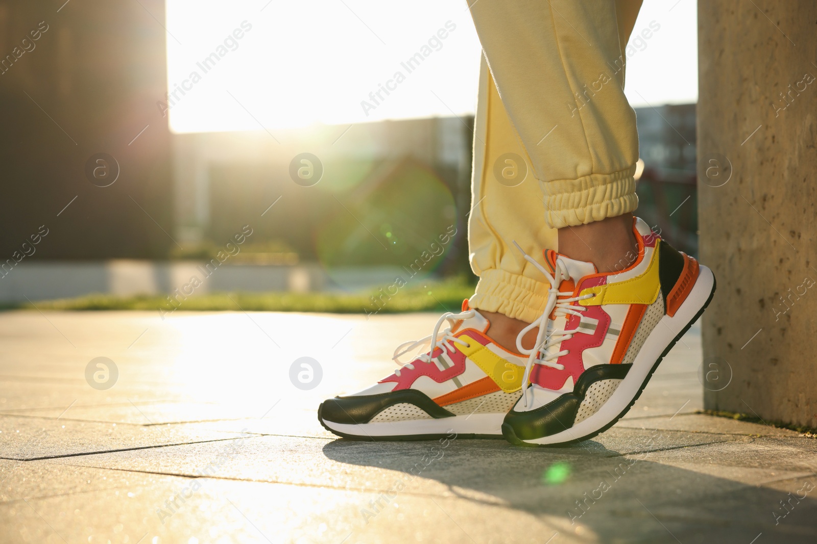 Photo of Woman wearing stylish sneakers outdoors, closeup. Space for text