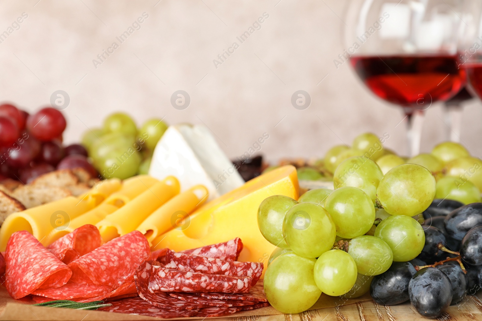 Photo of Different snacks and blurred glasses of wine on background