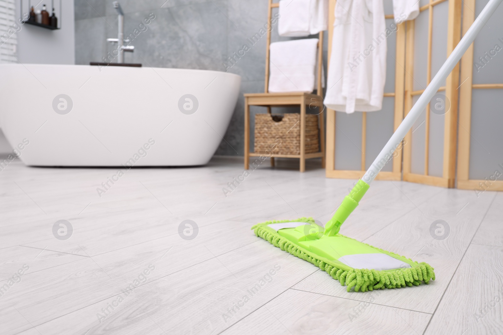 Photo of Cleaning dirty floor with mop in bathroom. Space for text
