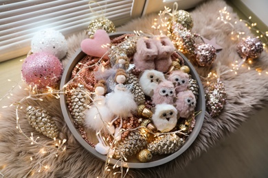 Photo of Beautiful Christmas tree baubles, toys and fairy lights on window sill, above view