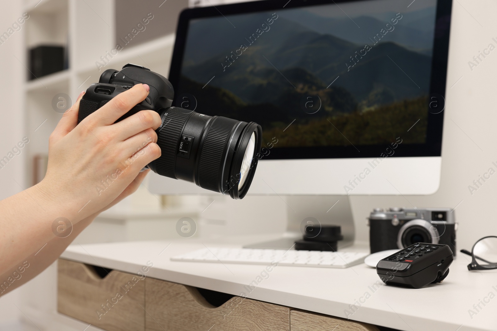 Photo of Photographer with camera at white table indoors, closeup