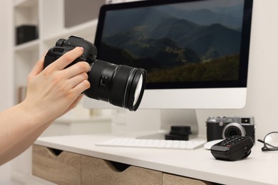 Photographer with camera at white table indoors, closeup