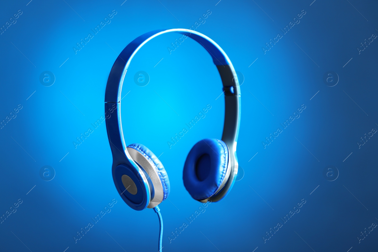 Photo of Stylish headphones with pads on color background