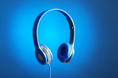 Photo of Stylish headphones with pads on color background