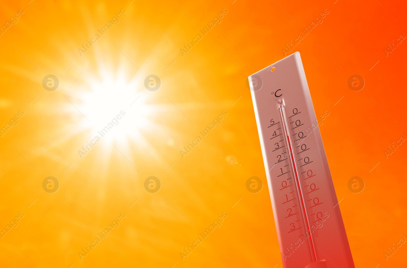 Image of Weather thermometer with high temperature outdoors on hot sunny day. Heat stroke warning