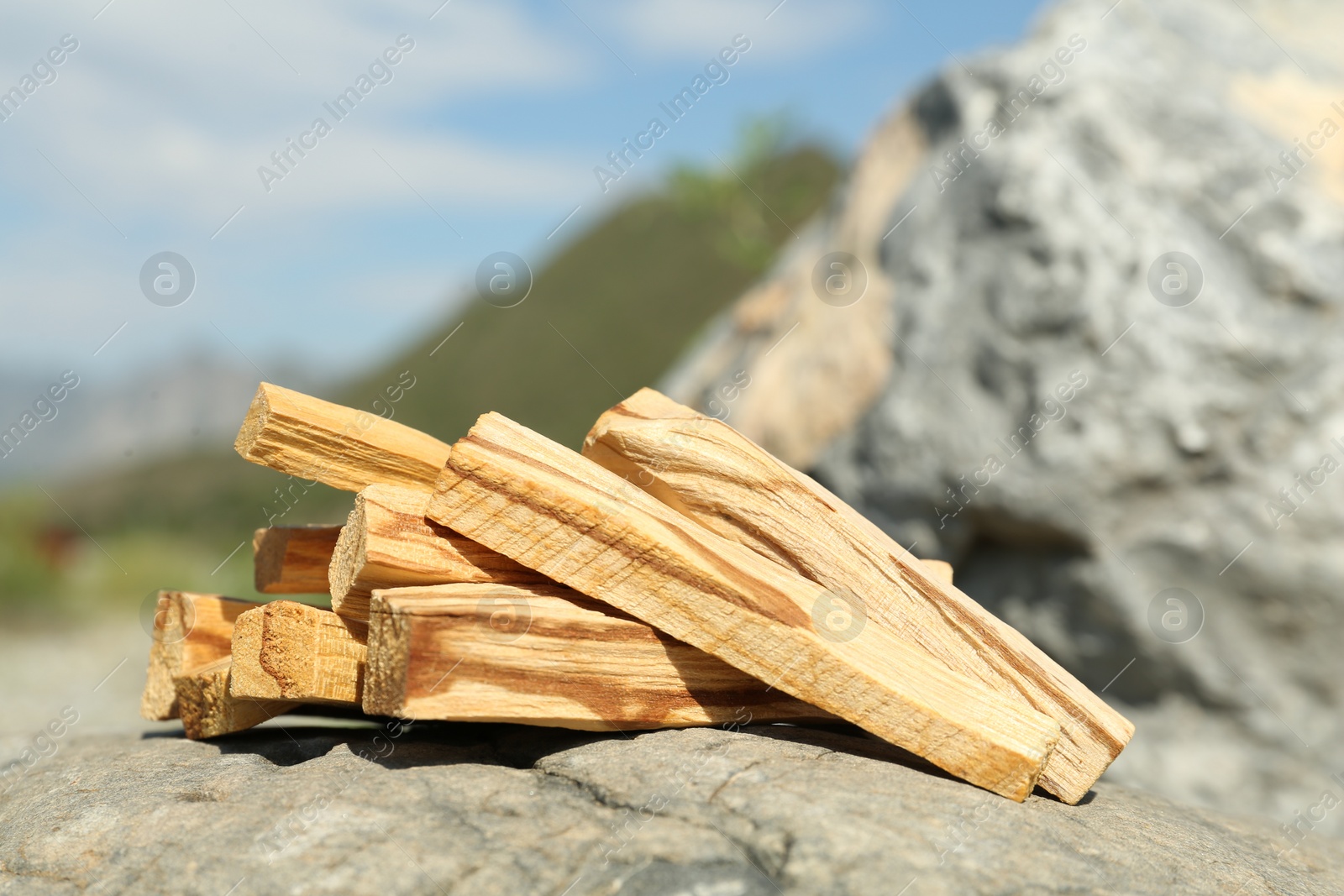 Photo of Many palo santo sticks on stone surface in high mountains, closeup