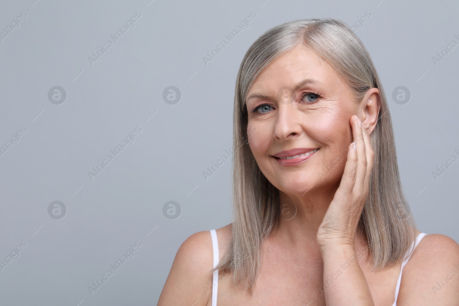 Photo of Portrait of beautiful senior woman on grey background. Space for text