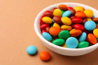 Tasty colorful candies on light brown background, closeup. Space for text