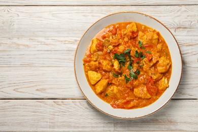 Delicious chicken curry on wooden table, top view. Space for text