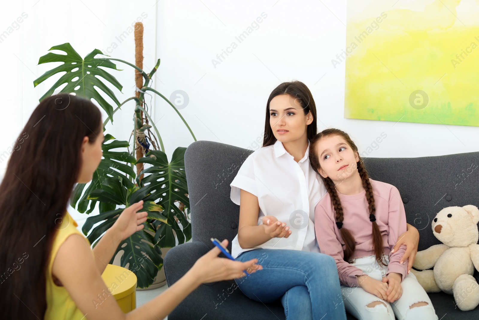 Photo of Young woman and her daughter having appointment with child psychologist in office