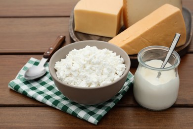Photo of Tasty cottage cheese and other fresh dairy products on wooden table