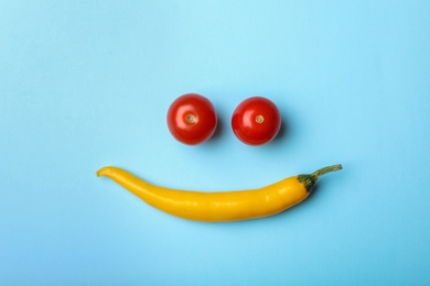 Photo of Funny flat lay composition with cherry tomatoes and chili pepper on color background