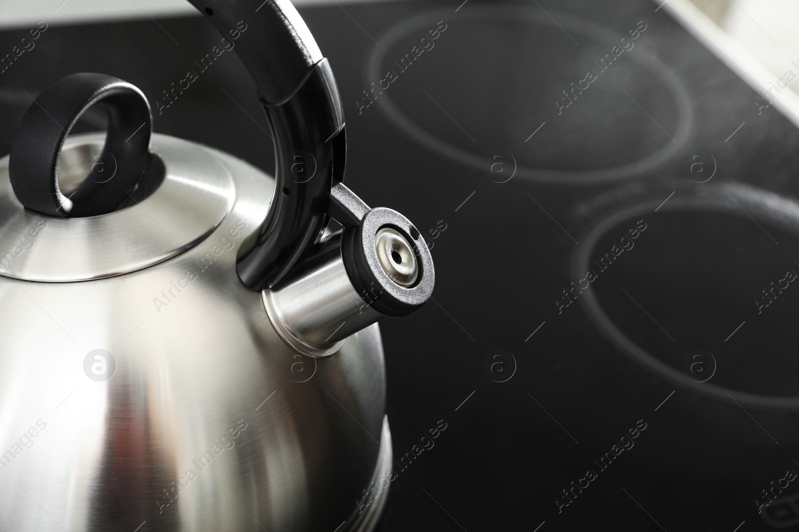 Photo of Modern kettle with whistle on stove, space for text