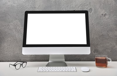 Photo of Workplace with modern computer monitor, keyboard and mouse on table. Mockup for design