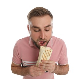 Photo of Young man eating delicious shawarma on white background