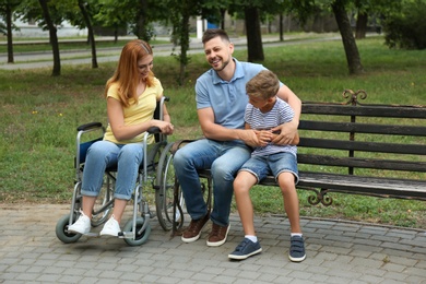 Photo of Woman in wheelchair with her family at park