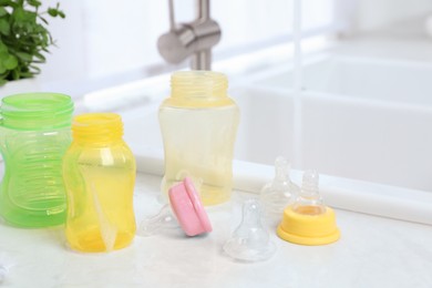 Photo of Baby bottles and nipples after washing on white countertop in kitchen