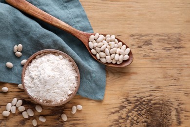 Photo of Kidney bean flour and seeds on wooden table, flat lay. Space for text
