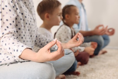 Photo of Family meditating together indoors, closeup. Harmony and zen