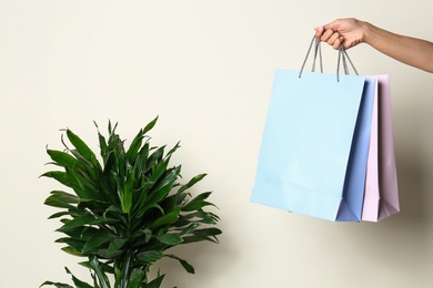 Woman with blank paper bags against color background, closeup. Space for text