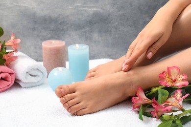 Woman with neat toenails after pedicure procedure on white terry towel, closeup