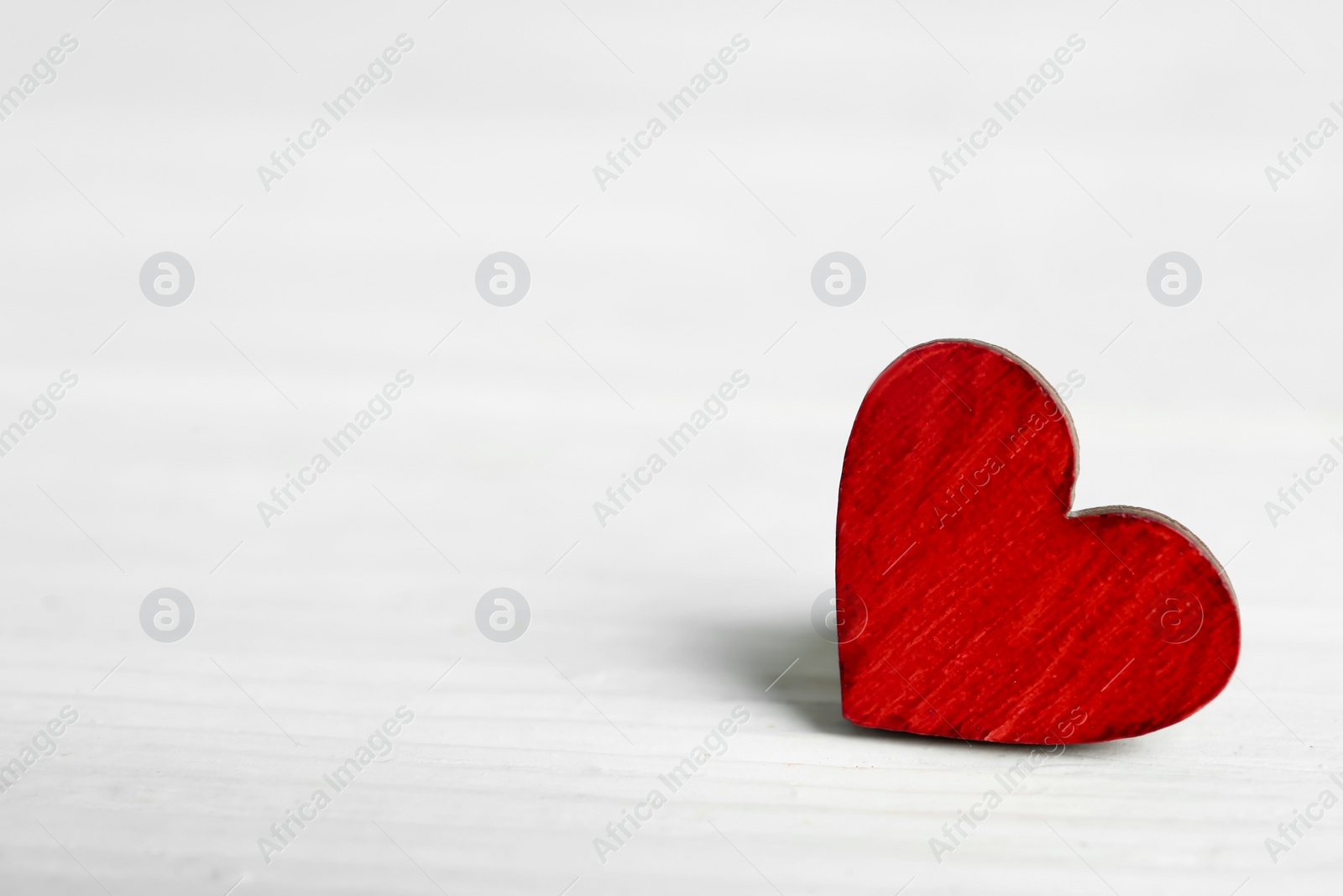 Photo of Decorative heart on white wooden table, space for text. Valentine's Day