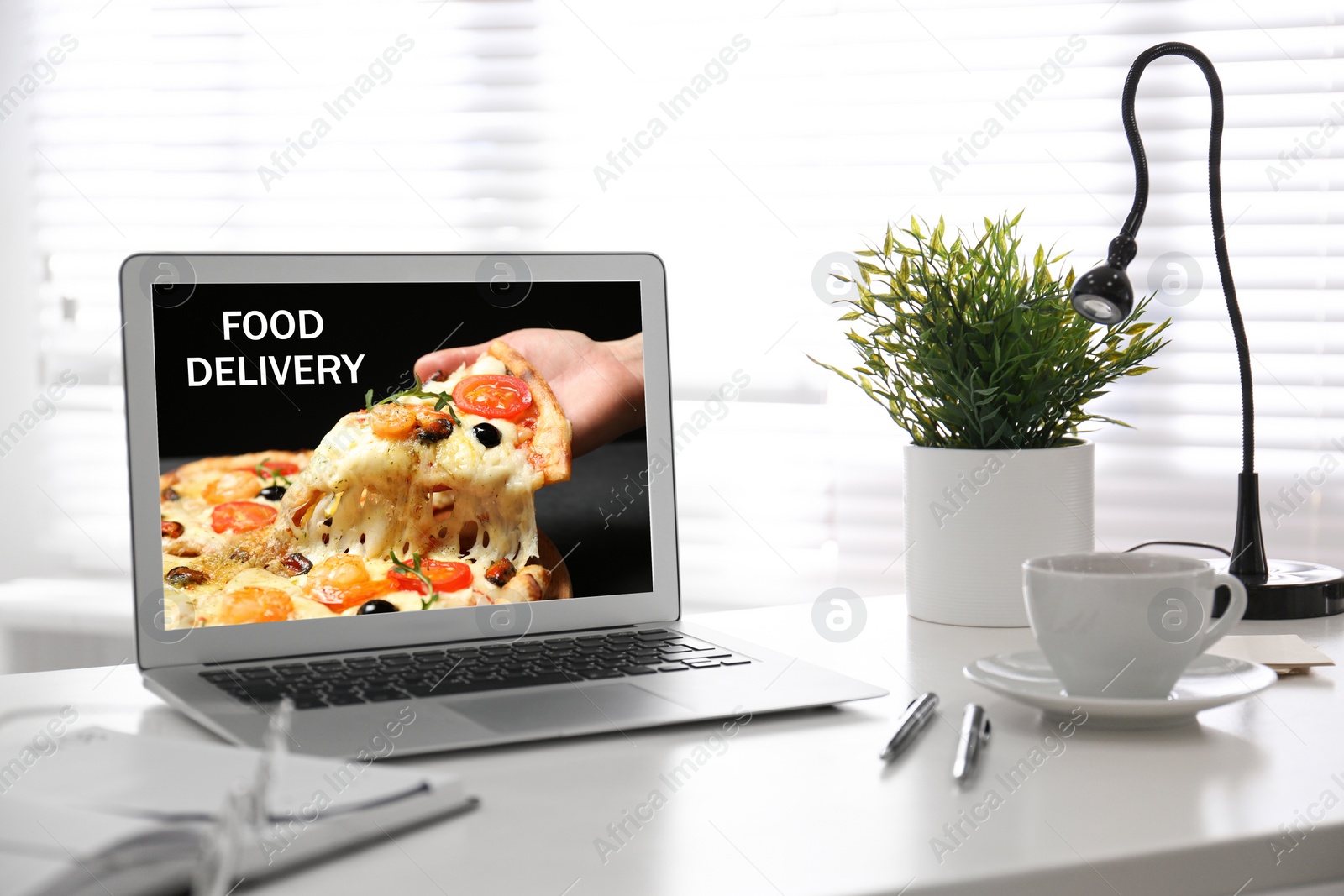 Image of Modern laptop with open page of food delivery service on screen