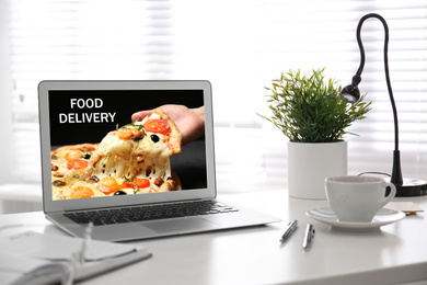 Modern laptop with open page of food delivery service on screen