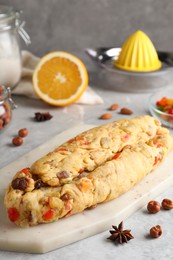 Photo of Unbaked Stollen with candied fruits and raisins on light marble table