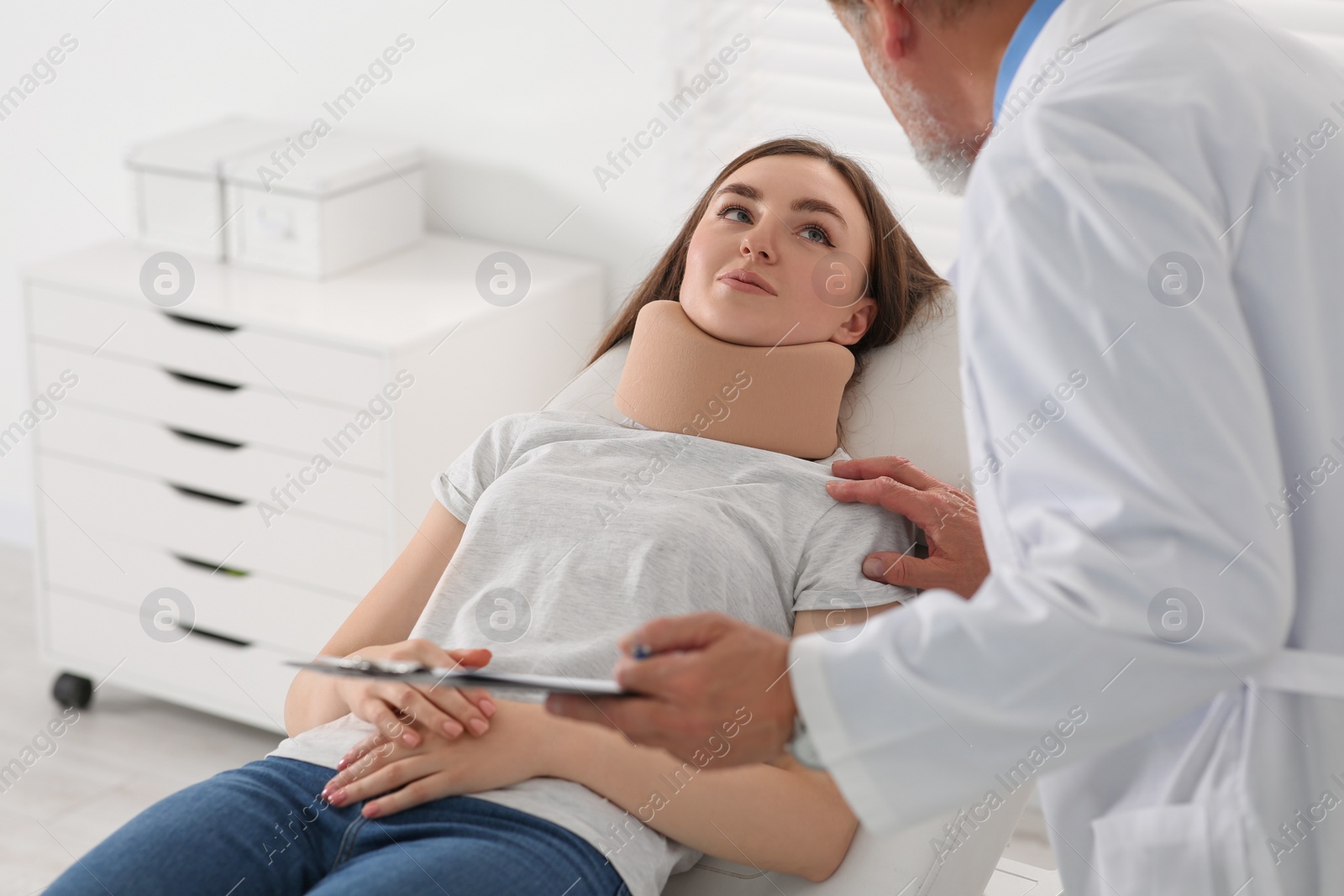 Photo of Orthopedist examining patient with injured neck in clinic, closeup