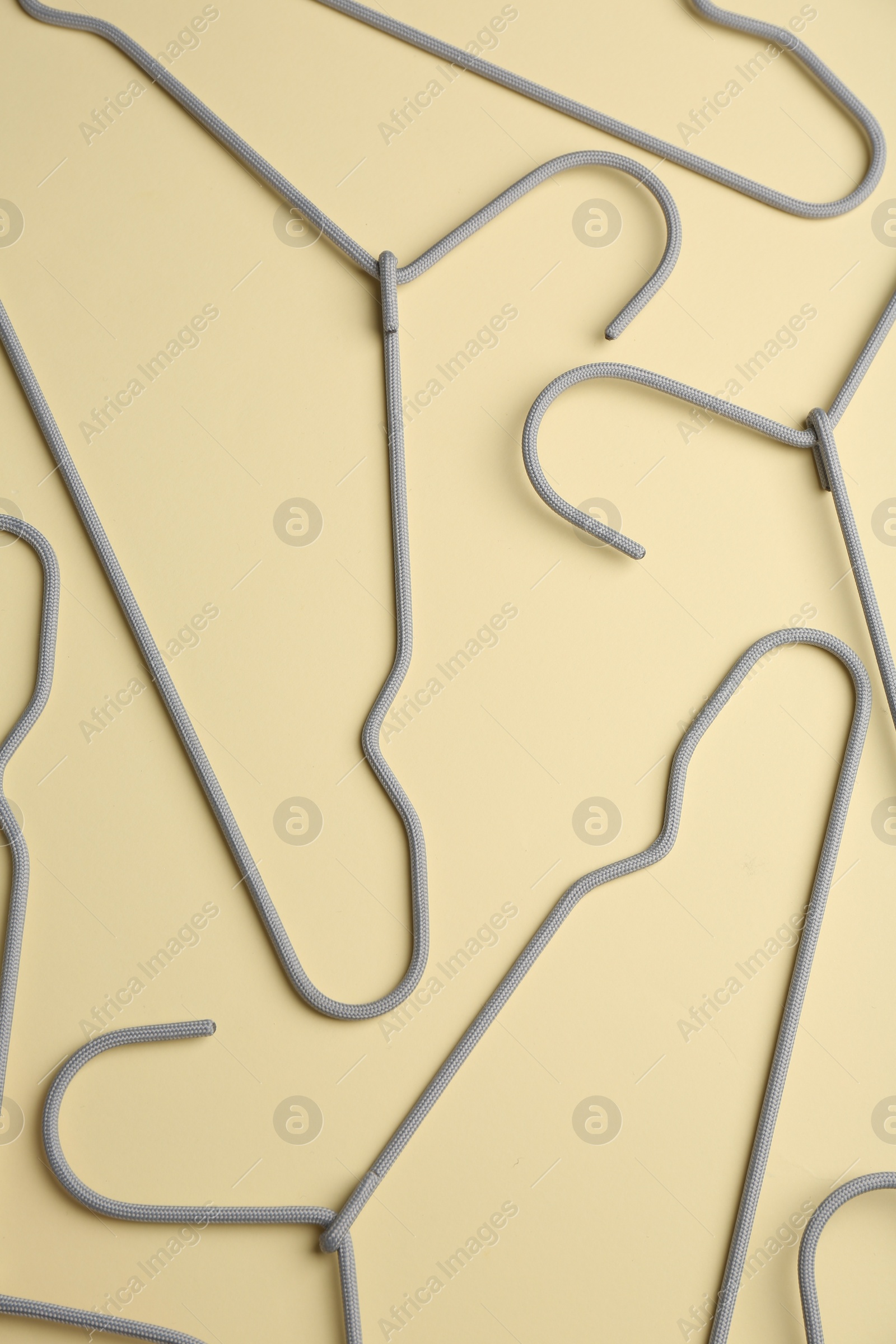 Photo of Hangers on pale yellow background, flat lay