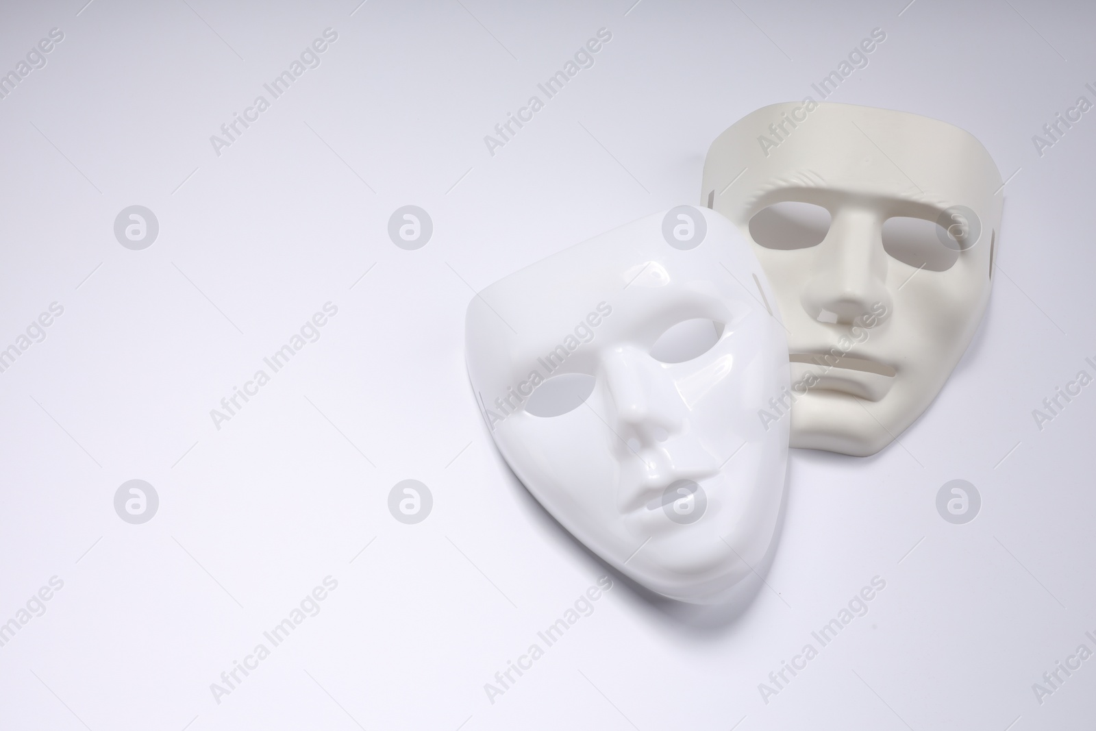 Photo of Theater arts. Two masks on white background, top view. Space for text