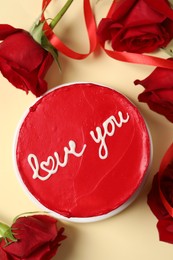 Photo of Bento cake with text Love You and red roses on beige table, top view. St. Valentine's day surprise