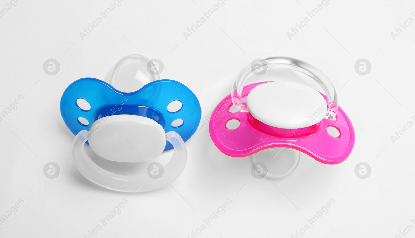 Photo of Baby pacifiers on white background, closeup view
