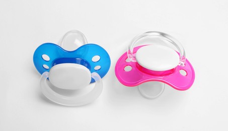Baby pacifiers on white background, closeup view