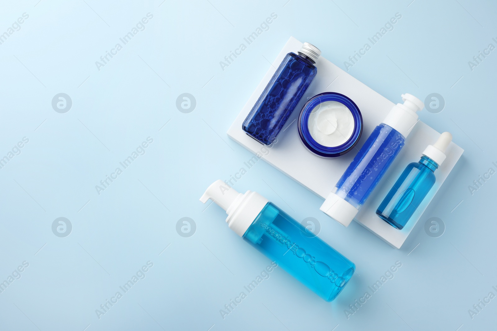 Photo of Set of cosmetic products on light blue background, flat lay. Space for text