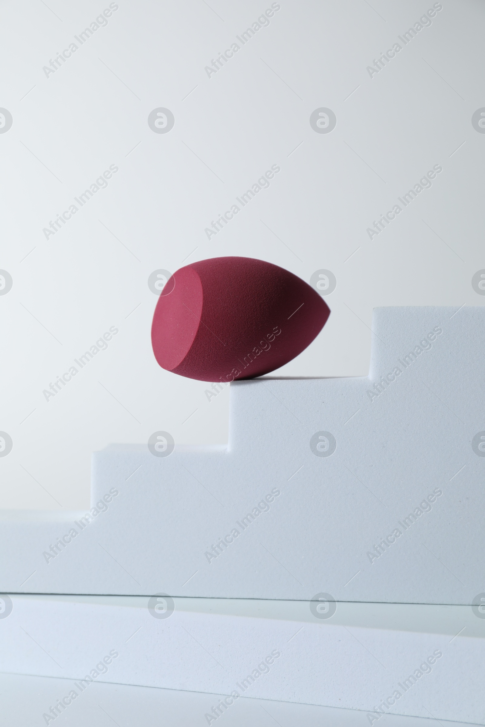 Photo of Stylish presentation of makeup sponge on white background