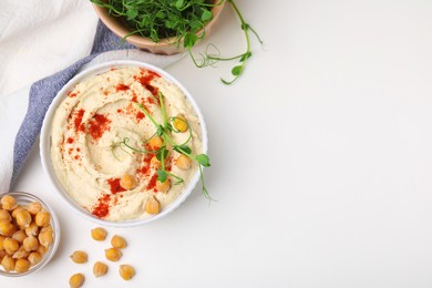 Photo of Delicious hummus with chickpeas and paprika served on white table, flat lay. Space for text