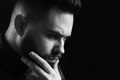 Photo of Portrait of handsome bearded man on dark background, space for text. Black and white effect