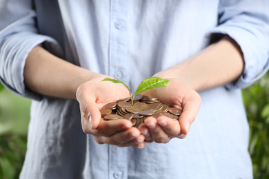 Woman holding coins and green sprout, closeup. Money savings