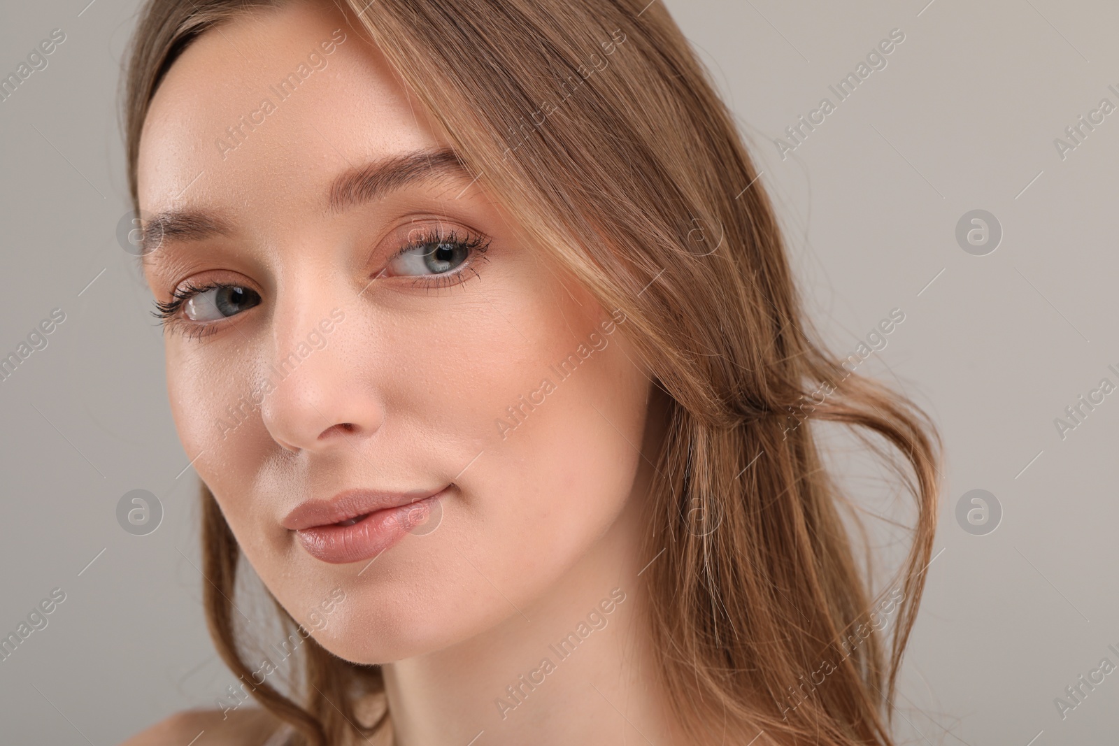 Photo of Beautiful woman with healthy skin on gray background, closeup