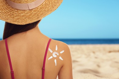 Image of Young woman with sun protection cream on sandy beach, space for text