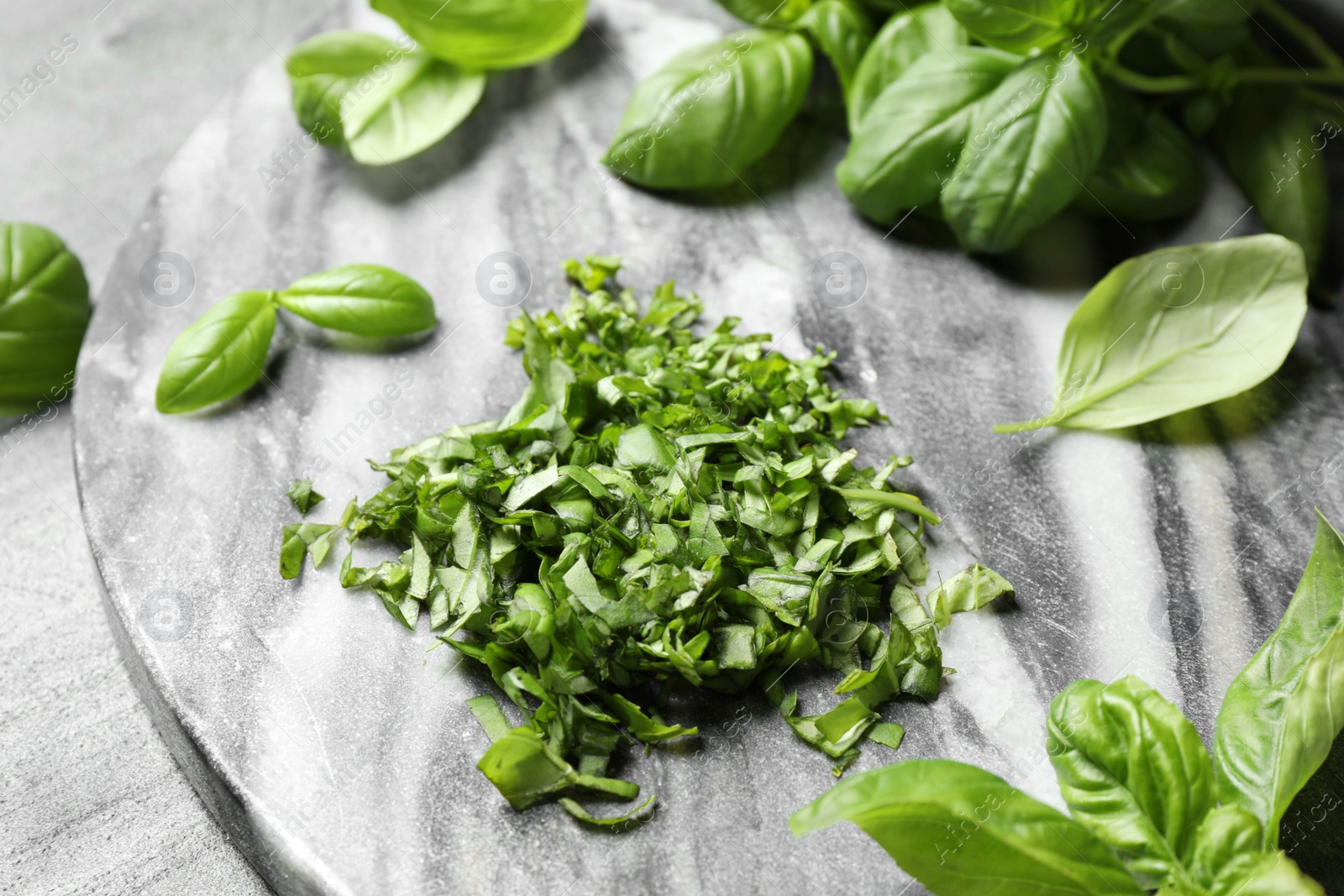 Photo of Fresh green basil on light grey table, closeup