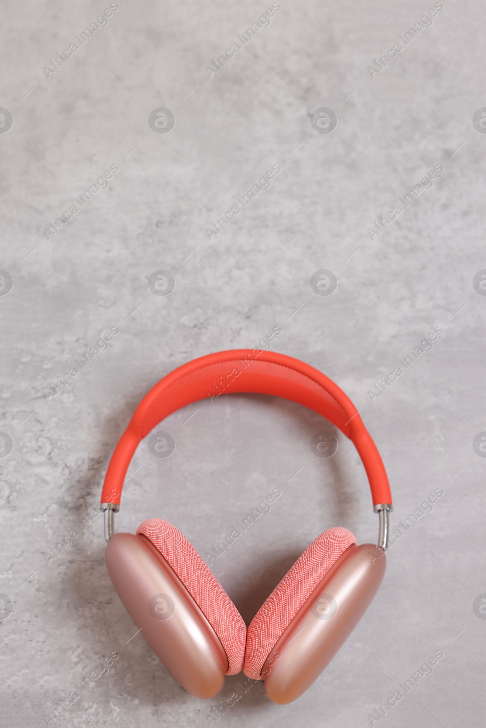 Photo of Stylish pink headphones on light grey table, top view. Space for text